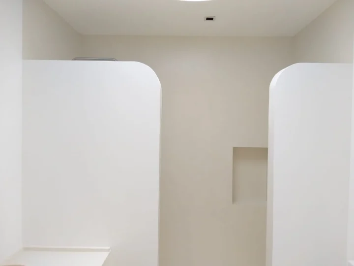 Tabiques de esquinas redondeadas y hornacina en pared lisa de un baño reformado